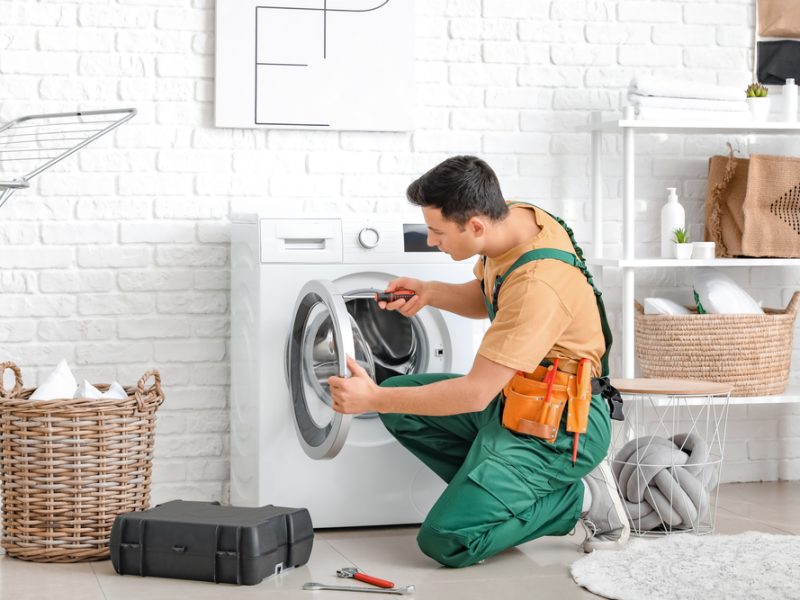 Worker,Repairing,Washing,Machine,In,Laundry,Room